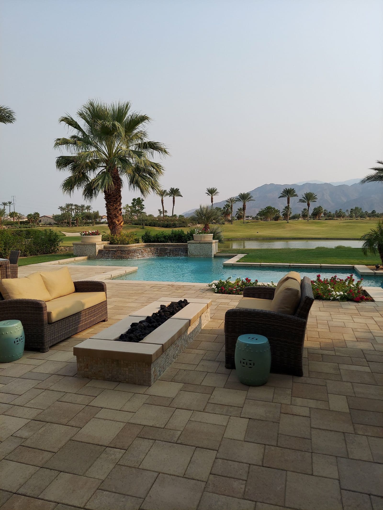 Resort-style paver patio with pool and lounge seating