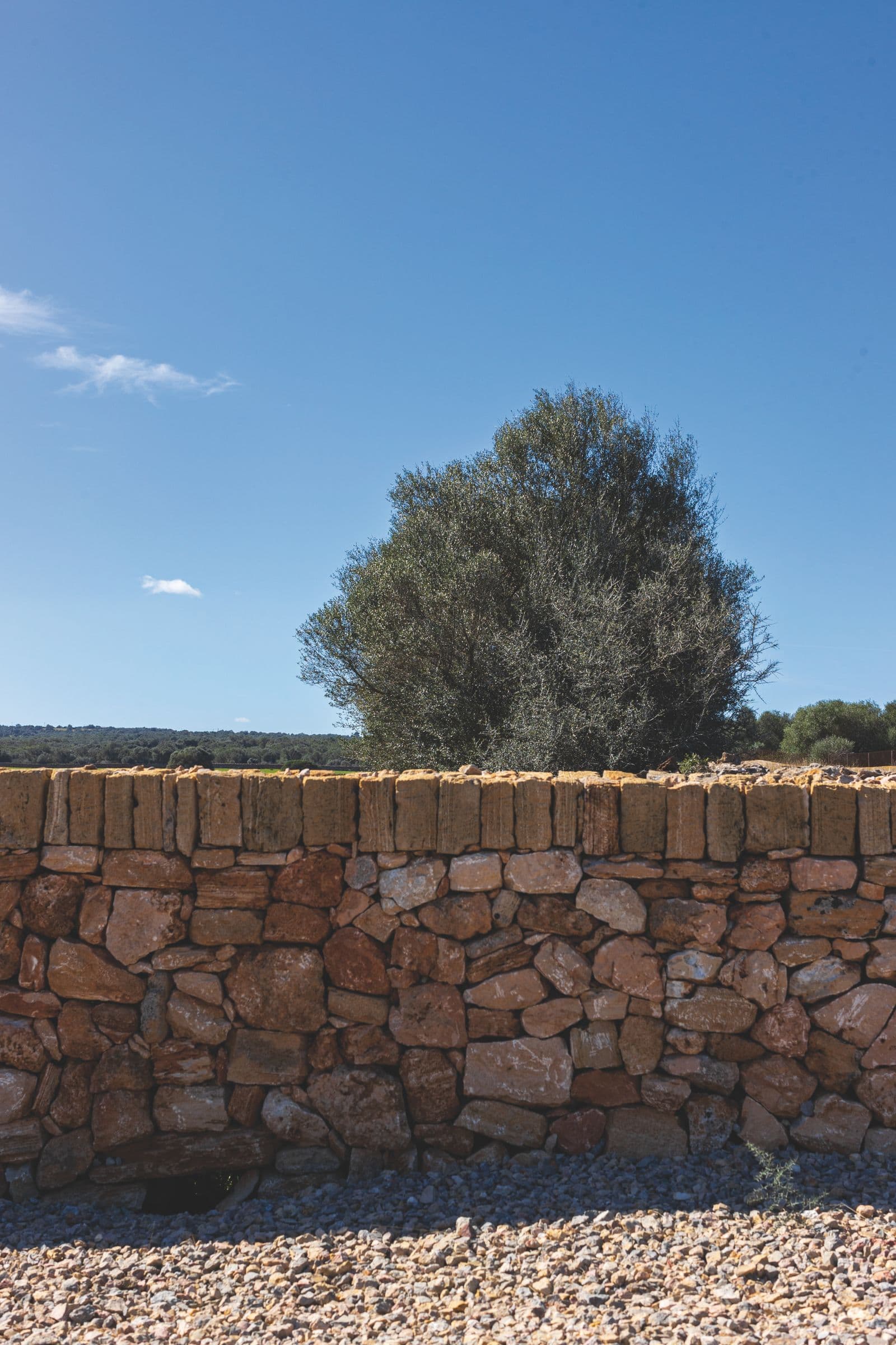 Cut-stone retaining wall with a gravel drainage bed