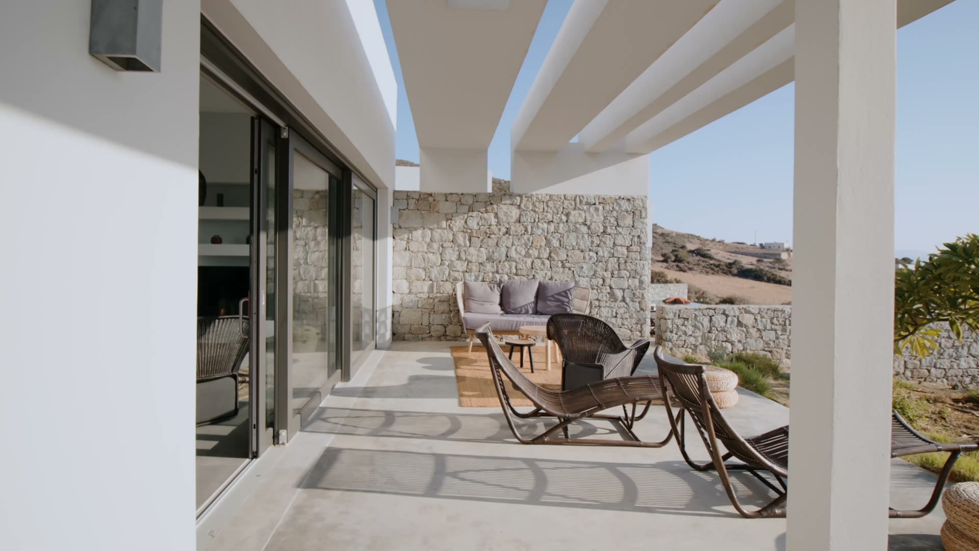 Slow pan across a stone-walled terrace in warm evening light