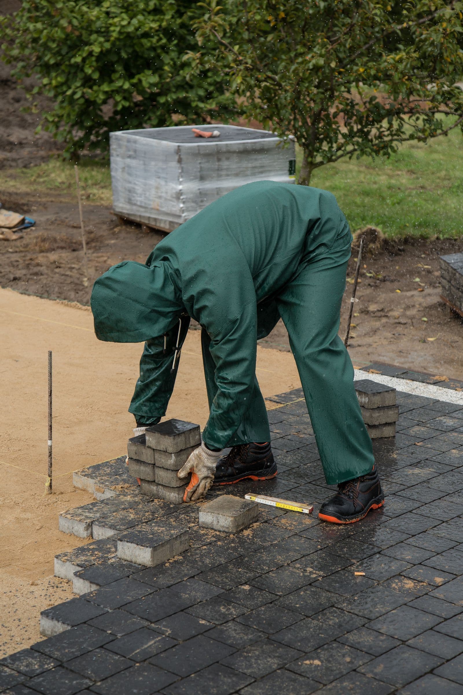 Crew member laying block pavers on a prepared base